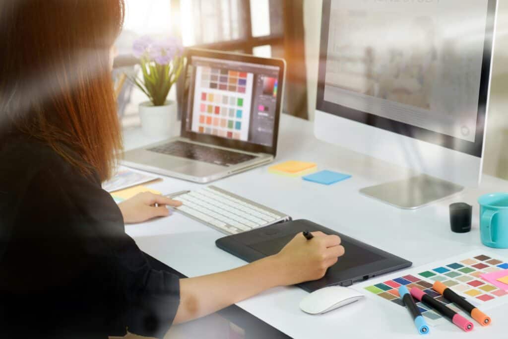 A girl at her laptop, diligently designing a custom theme to represent her company's brand identity through WordPress