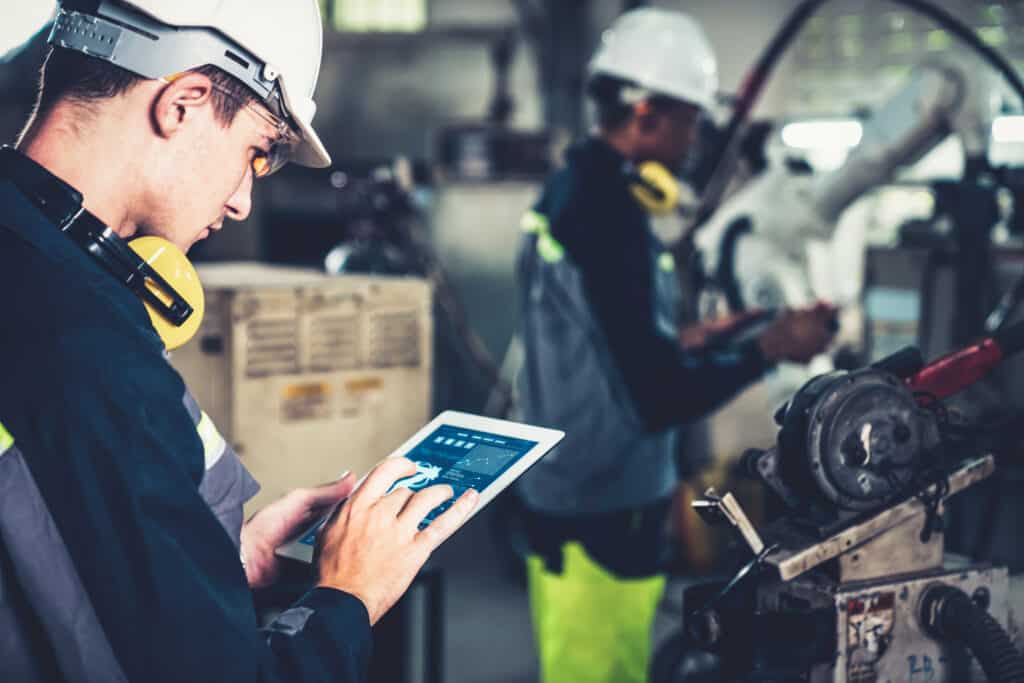 A factory worker checking and updating his website to ensure it runs on the latest secure software